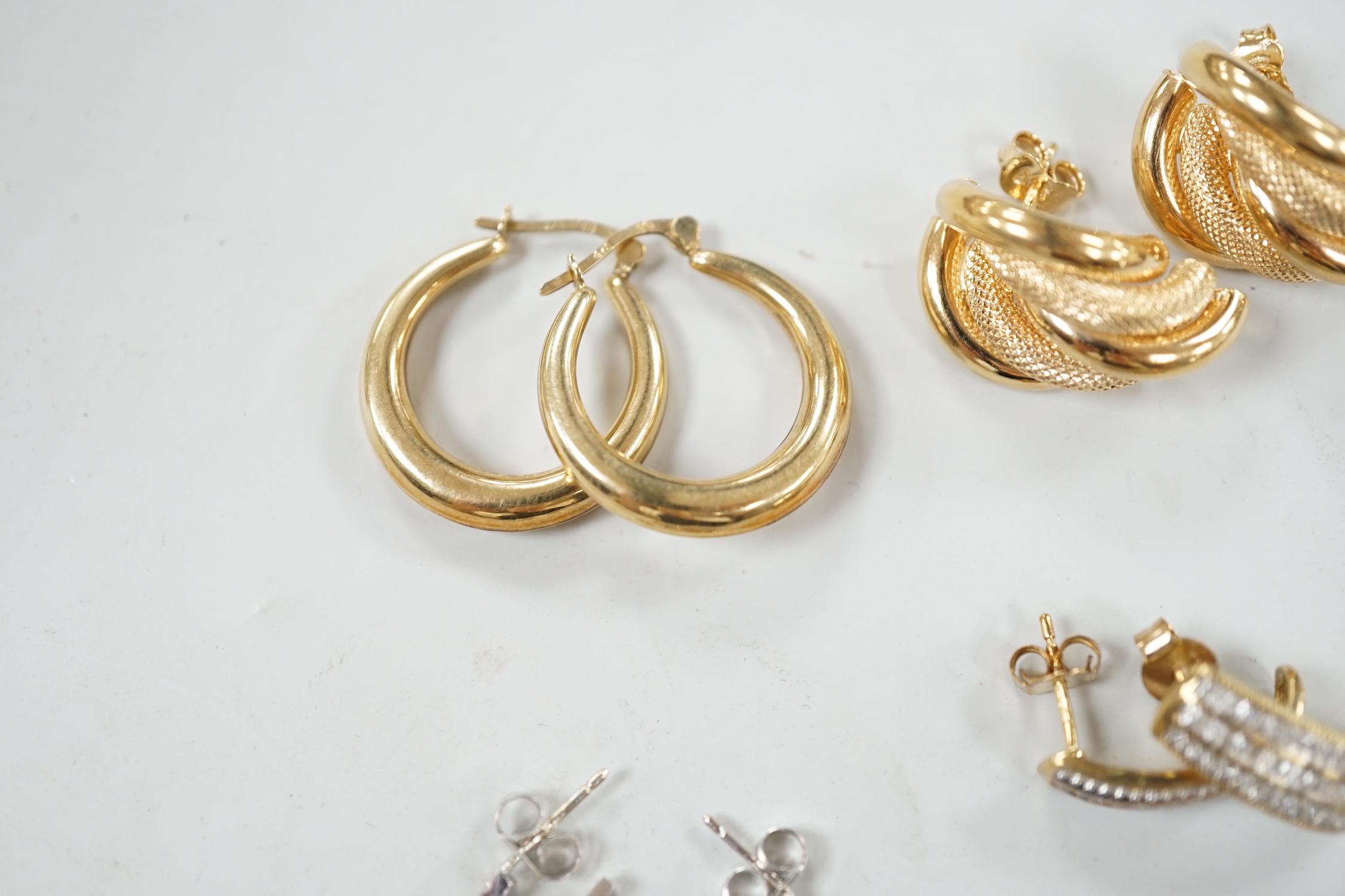Two modern pairs of 9ct hoop or half hoop earrings and two pairs of 9ct and diamond chip set earrings including white gold, gross weight 10.9 grams.